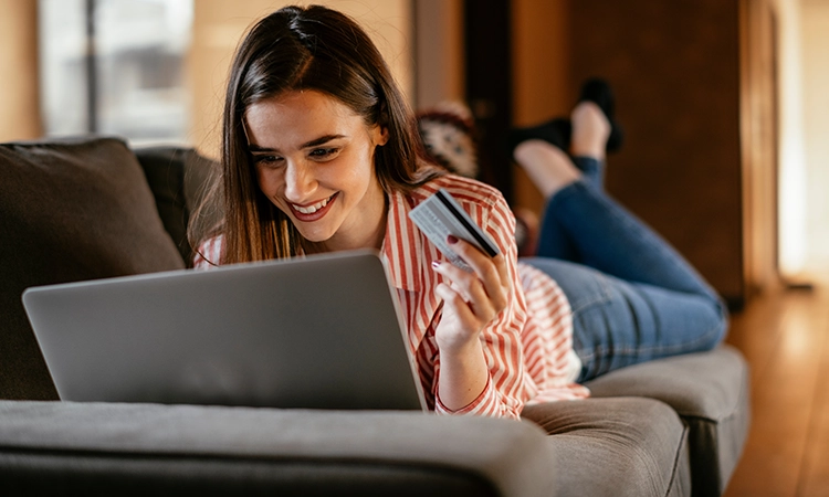 woman on laptop with debit card